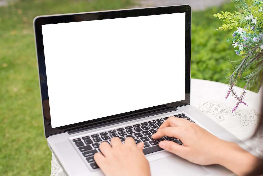 Young women using laptop computer on table at garden . view side. mock up screen free space for your design garden design during a pandemic